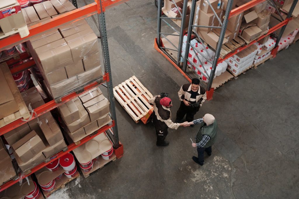 three people in warehouse shaking hands